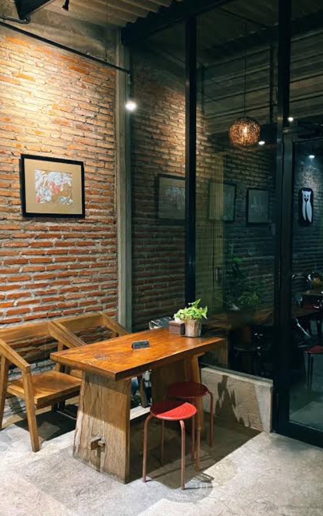 Wooden table seating against brick wall